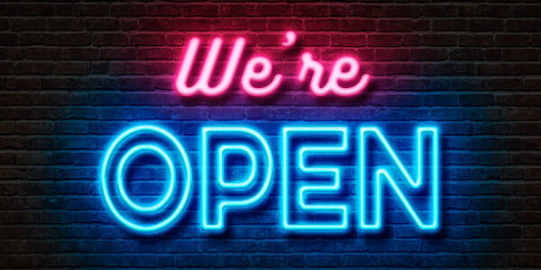 Neon sign on a brick wall - We are open